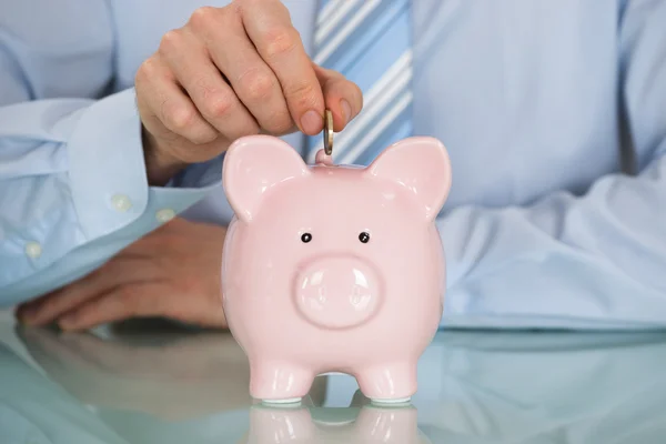 Businessman Inserting Coin In Piggy Bank — Stock Photo, Image