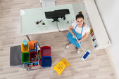 Female Janitor Mopping Wooden Floor