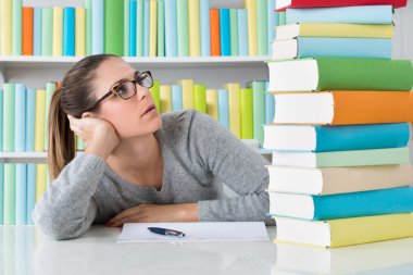 kitap yığını ile oturan kadın