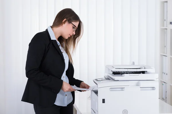 Zakenvrouw met behulp kopieermachine — Stockfoto