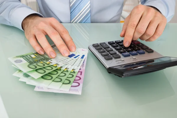 Hombre con billetes y calculadora —  Fotos de Stock