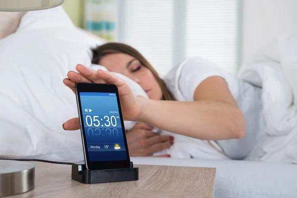 Woman On Bed Snoozing Alarm