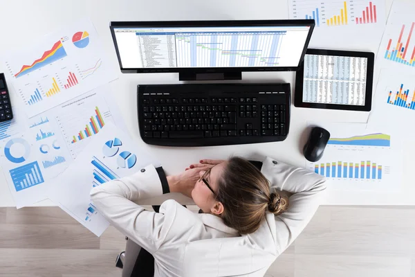 Empresária com gráficos dormindo na mesa — Fotografia de Stock