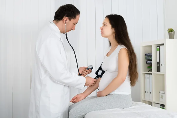 Verificando a pressão arterial da mulher grávida — Fotografia de Stock