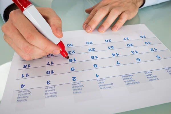 Empresario destacando fecha en el calendario — Foto de Stock