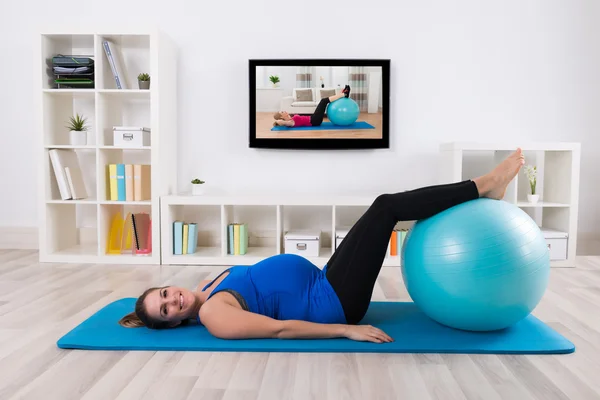 Jovem grávida do sexo feminino fazendo exercício — Fotografia de Stock