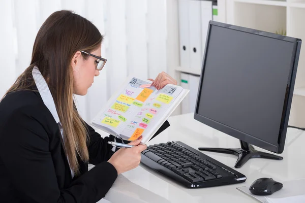 Geschäftsfrau schaut auf Tagebuch — Stockfoto