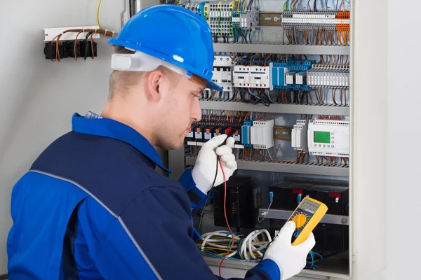 Technicus onderzoekende fusebox — Stockfoto