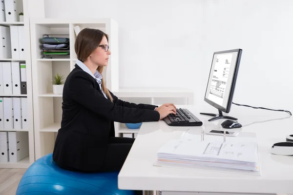 Geschäftsfrau auf Pilates-Ball mit Computer — Stockfoto