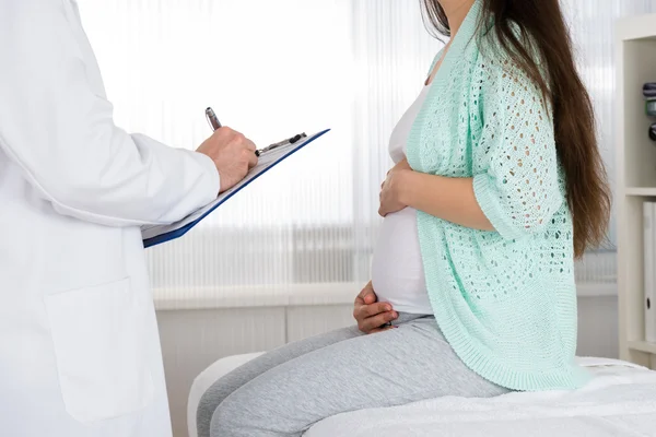 Médico com prescrição para mulher grávida — Fotografia de Stock