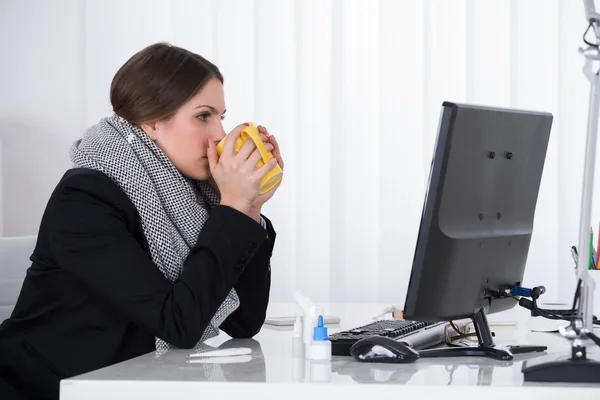 Zakenvrouw drinken met mok aan balie — Stockfoto