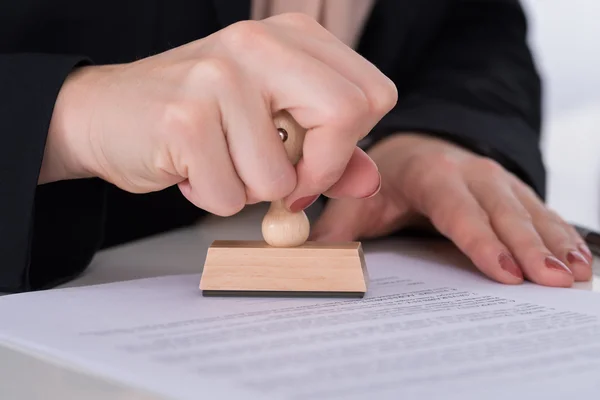 Geschäftsmann verwendet Stempel auf Dokument — Stockfoto