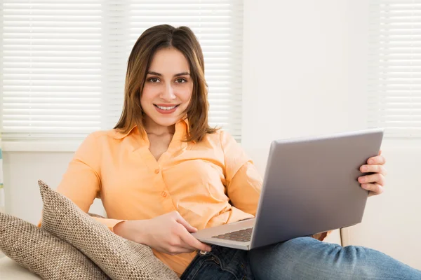 Mujer joven sonriente con portátil — Foto de Stock