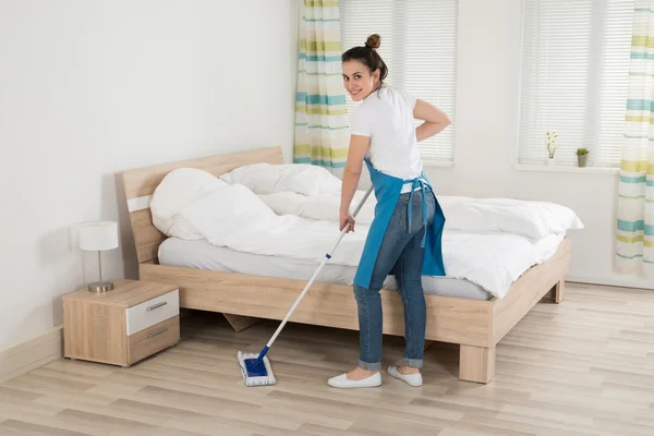 Kvinnlig hushållerska Mopping golv — Stockfoto