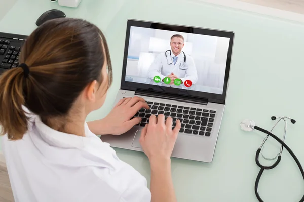 Female Doctor Video Chatting On Laptop Stock Picture