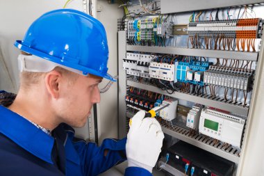 Male Electrician Examining Fusebox clipart