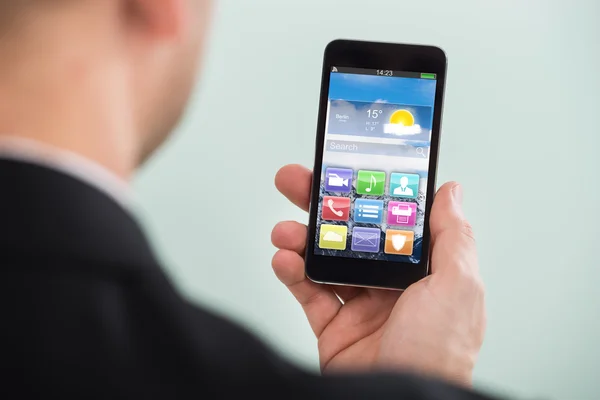 Hombre de negocios sosteniendo smartphone — Foto de Stock