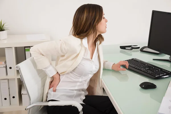 Mujer de negocios que sufre de dolor de espalda — Foto de Stock