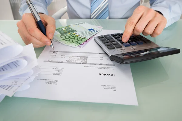 Businessman Calculating Invoice In Office — Stock Photo, Image