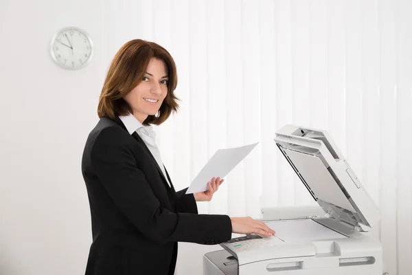 Empresária copiando papel na máquina — Fotografia de Stock