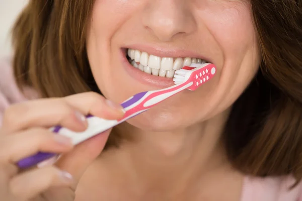 Mulher escovando dentes com escova de dentes — Fotografia de Stock