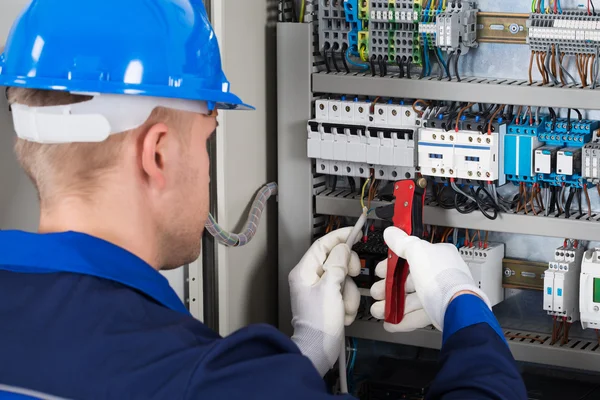 Eletricista masculino reparando Fusebox — Fotografia de Stock