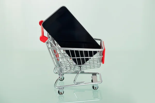 Teléfono celular en el carrito de la compra — Foto de Stock