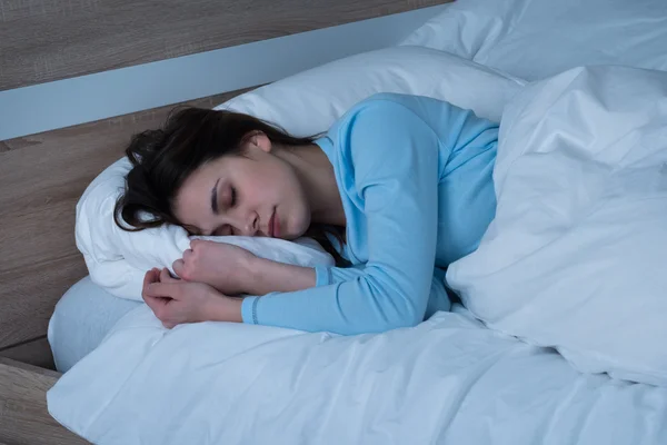 Женщина спит на кровати — стоковое фото