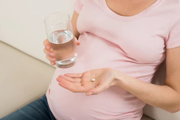 Mujer embarazada con píldora de vitamina — Foto de Stock