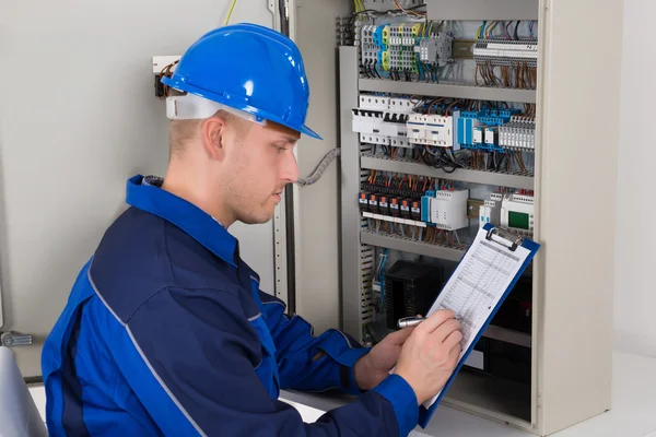 Jonge mannelijke technicus onderzoeken Fusebox — Stockfoto