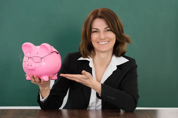 Female Teacher Holding Piggybank — Stock Photo, Image