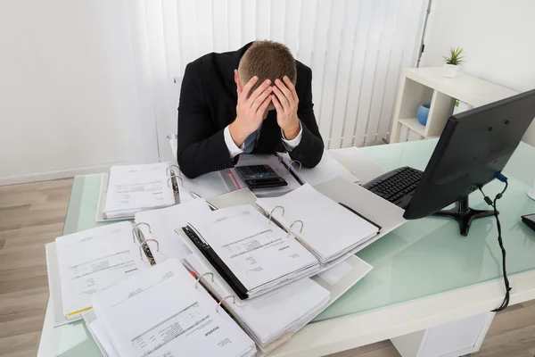 Homme d'affaires stressé assis au bureau — Photo