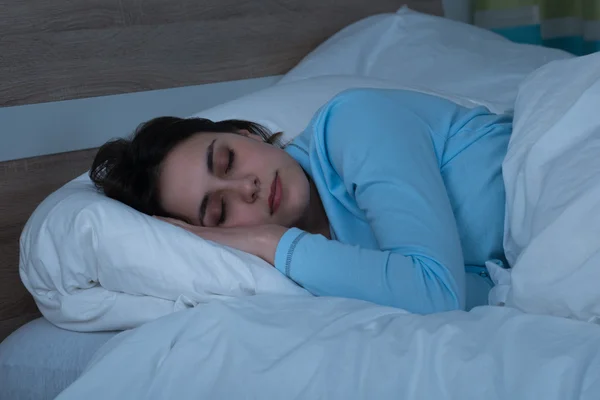 Kobieta śpiąca na łóżku — Zdjęcie stockowe