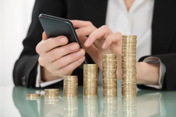 Mujer de negocios con monedas apiladas — Foto de Stock