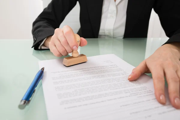 Geschäftsfrau mit Stempel auf Dokument — Stockfoto