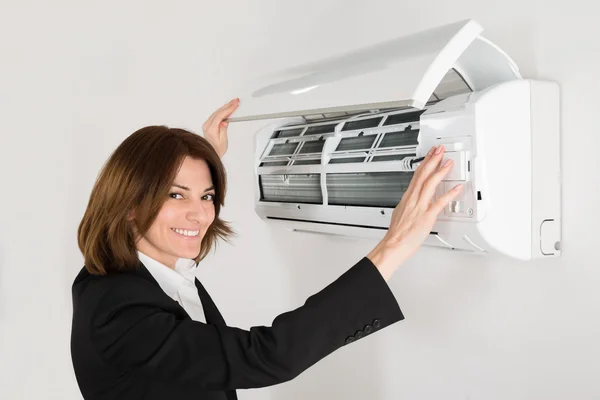 Businesswoman Comprobación de aire acondicionado — Foto de Stock