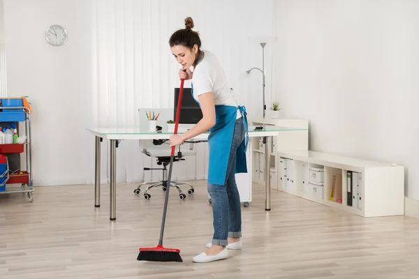 Vrouwelijke Janitor vegen vloer — Stockfoto