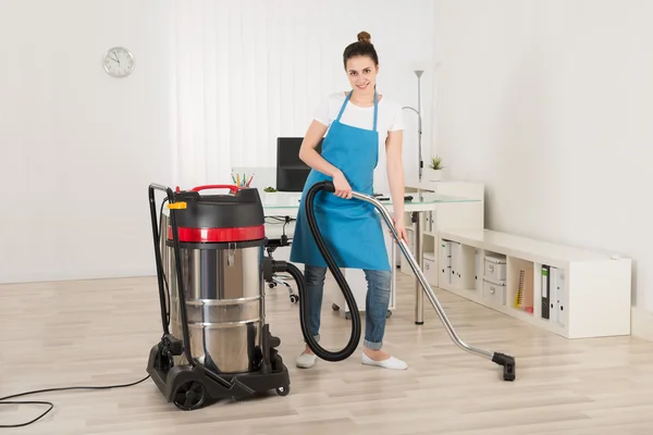 Janitor feminino com aspirador de pó — Fotografia de Stock