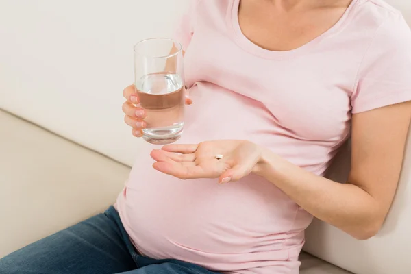 Mujer embarazada con píldora de vitamina — Foto de Stock