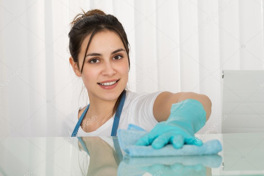 Female Janitor Cleaning Desk