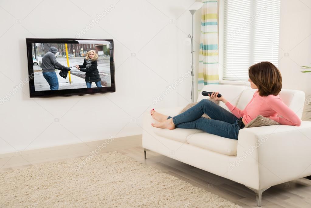 Woman Holding Remote near Television