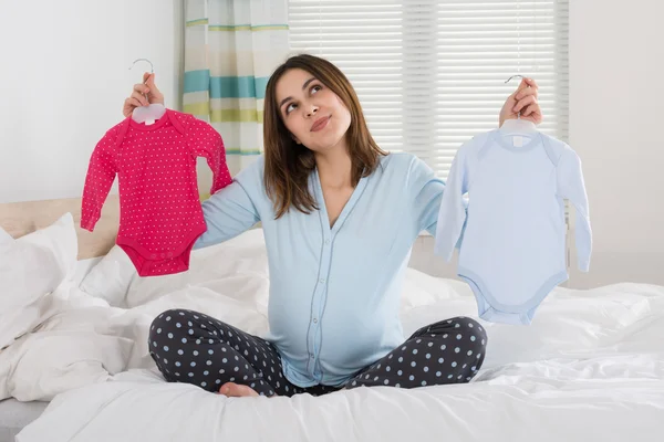 Mujer sosteniendo ropa de bebé — Foto de Stock