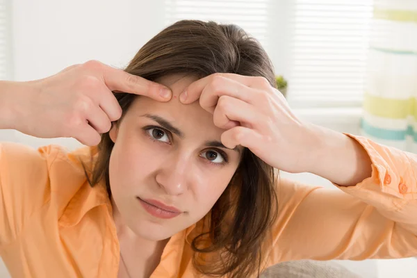 Mujer apretando espinilla — Foto de Stock