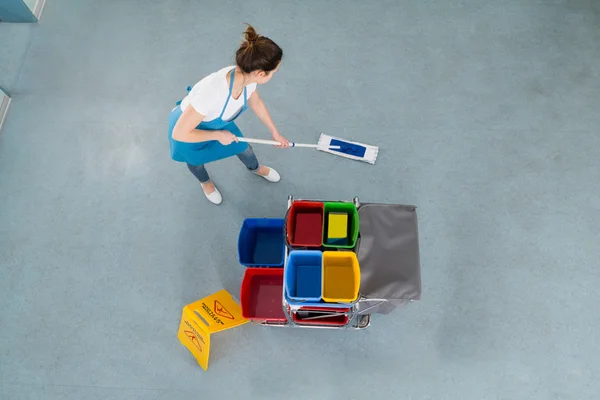 Feminino zelador esfregando chão — Fotografia de Stock