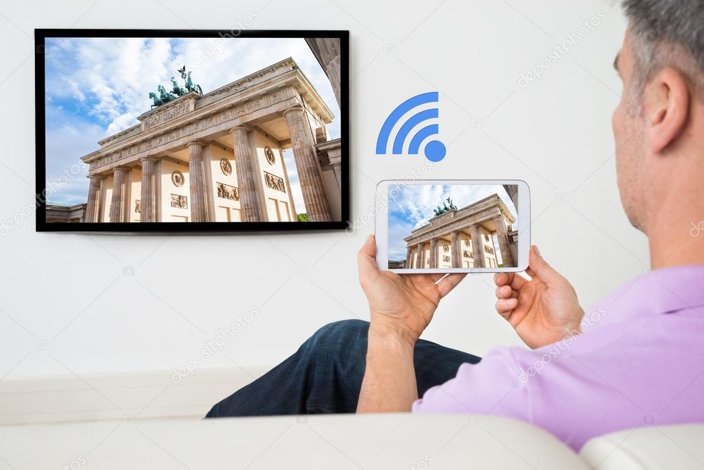 Holding Smartphone Connected To A TV