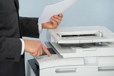 Businessman Pressing Printer's Button clipart