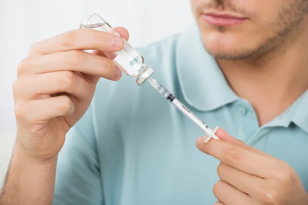 Homme avec bouteille de médicament et seringue — Photo