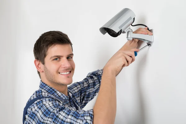 Joven técnico ajustando cámara cctv — Foto de Stock