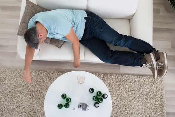 Мужчина дремлет на диване дома — стоковое фото