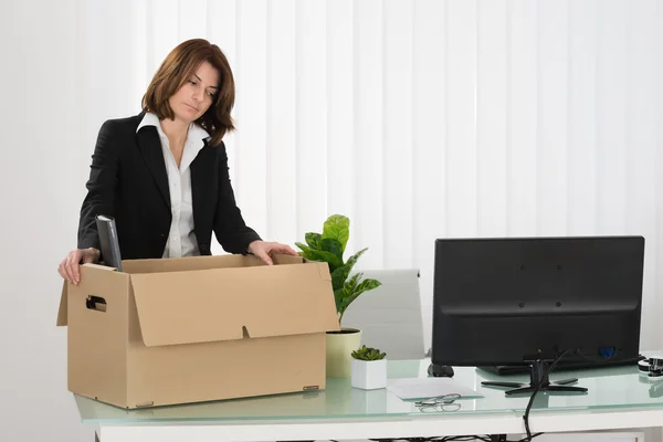 Vrouw die haar bezittingen In Box verpakking — Stockfoto